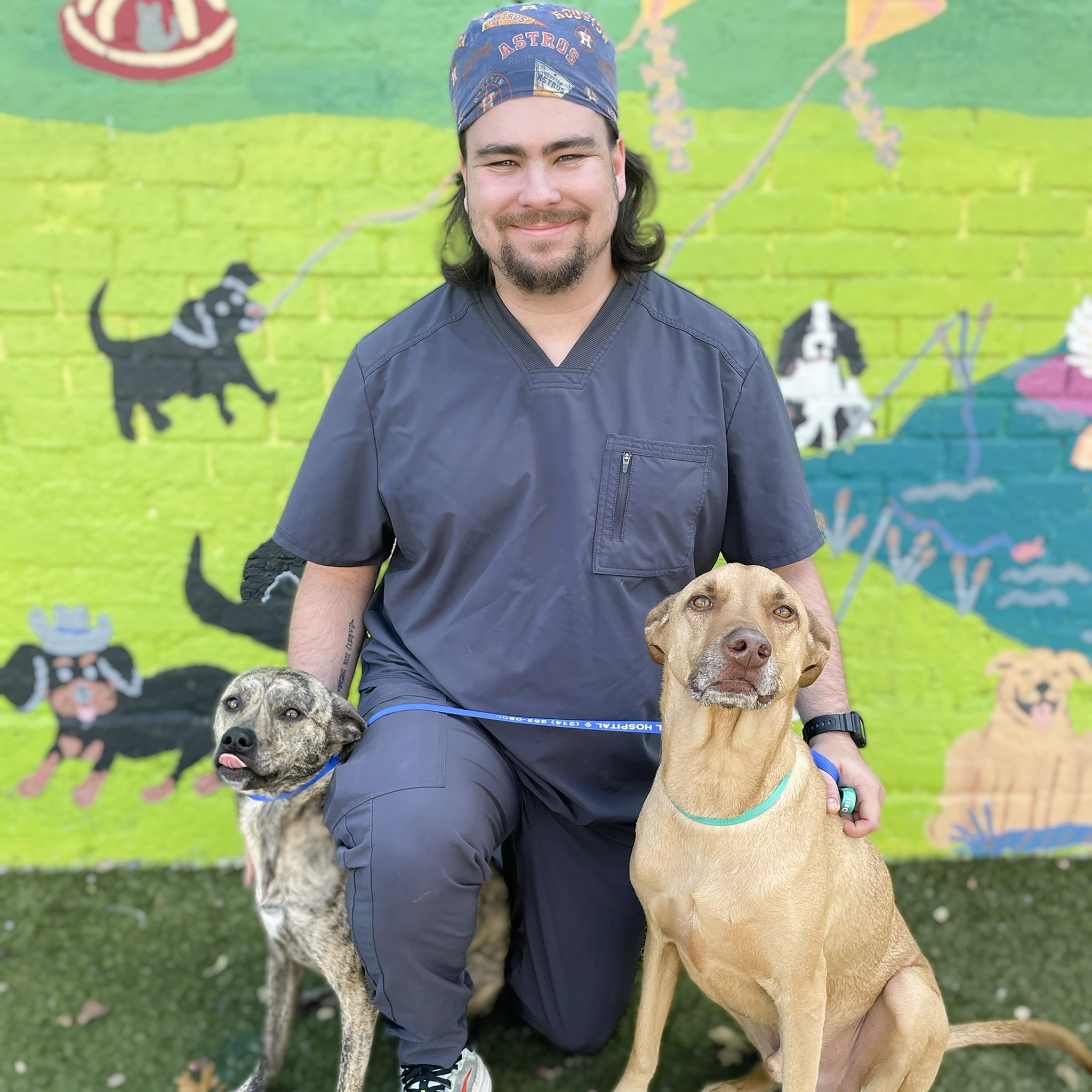 manager sitting with two dogs